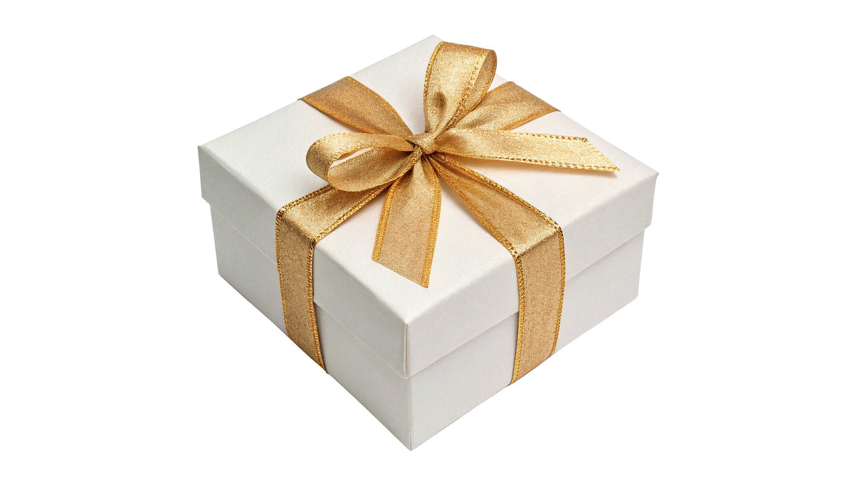 A white gift box tied with a wide golden ribbon and bow