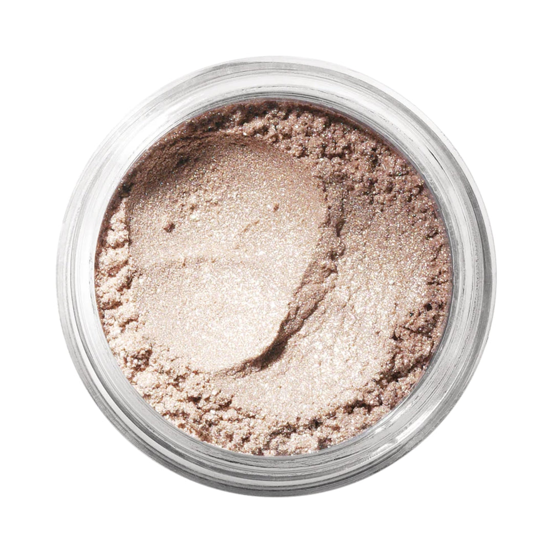 Small jar of loose mineral eyeshadow in warm nude shade, fine powder texture