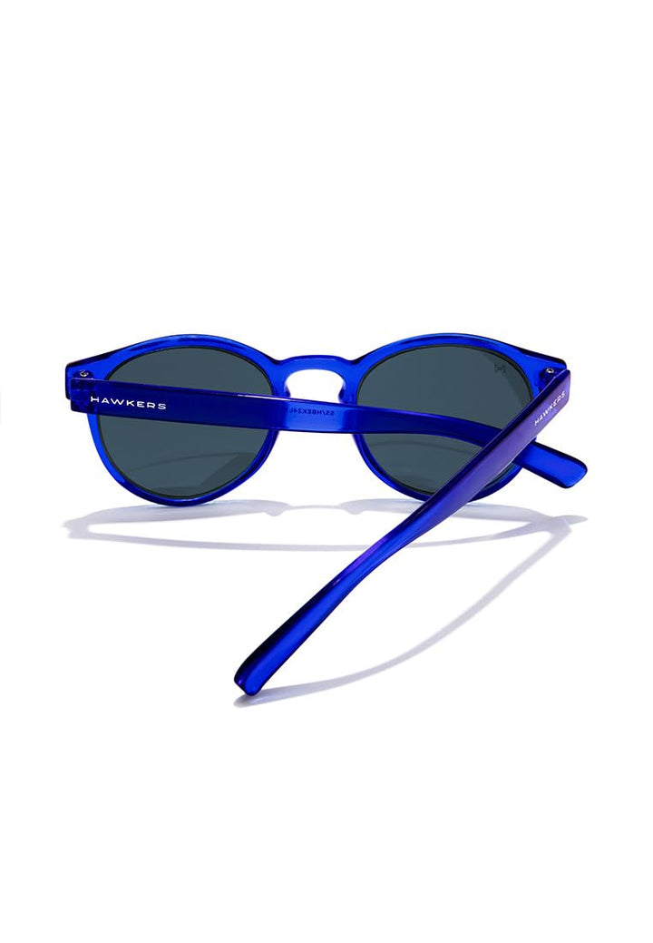 Hawkers round kids sunglasses, transparent blue plastic frame, keyhole bridge, dark round lenses