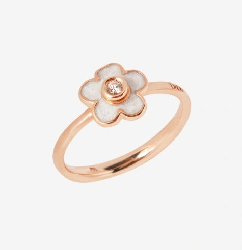 Rose gold and white enamel floral ring featuring central diamond on a neutral background, close-up view