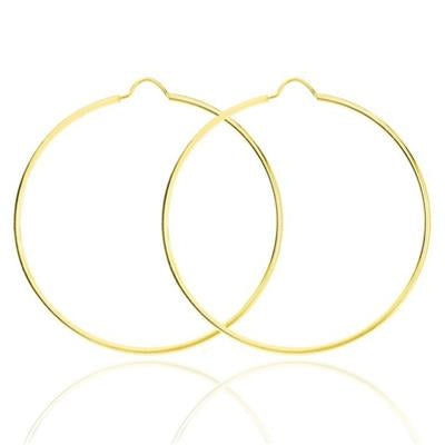 Thin round gold hoop earrings on a neutral background, minimalist slim profile visible